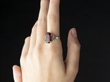 someone is holding their hand up with a ring on their finger