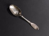 a spoon that is sitting on a black surface