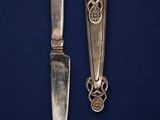 a pair of silver plated knives on a blue background