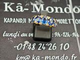 une photo d'une bague en or sertie de pierres bleues