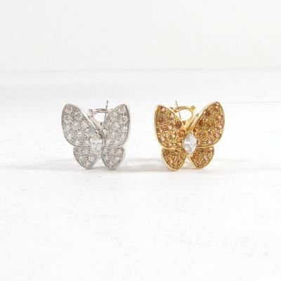une paire de boucles d'oreilles en forme de papillon, dorées et argentées, sur fond blanc