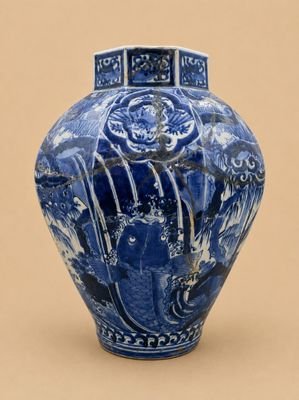 un vase bleu et blanc posé sur une surface beige clair