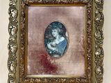 Une vieille photo d'une femme en robe bleue est accrochée au mur.
