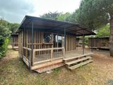 a small wooden cabin with a porch and a covered porch