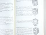 an open book with a picture of a coat of arms on it