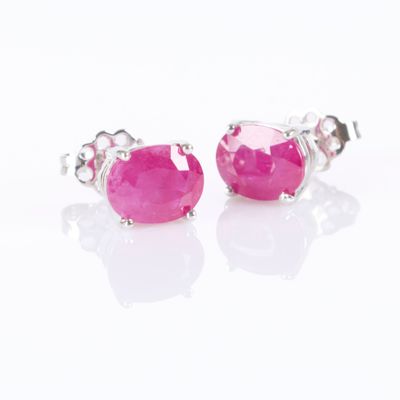 une paire de boucles d'oreilles à clous en pierre rose sur fond blanc