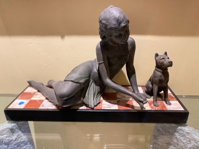a statue of a woman and a dog on a table