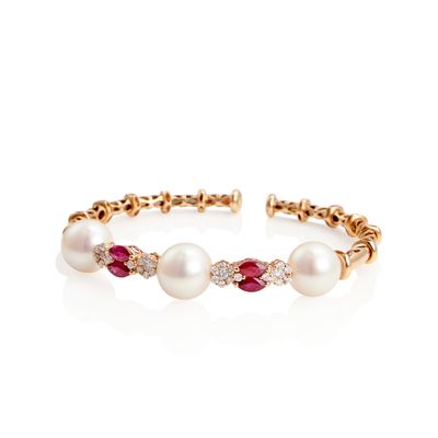 a close up of a bracelet with pearls and diamonds on a white background