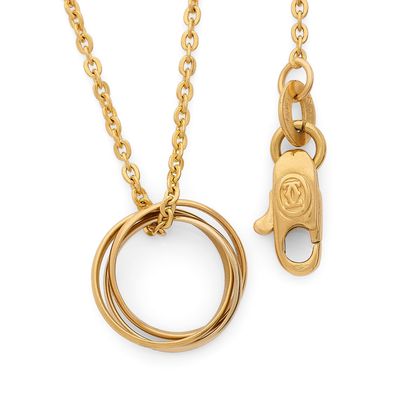 un gros plan sur un collier en or et une bague en or suspendus à une chaîne