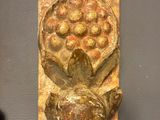 a wooden carving on the wall next to a bottle of wine
