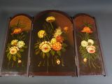 three panels with flowers painted on them hanging on a wall