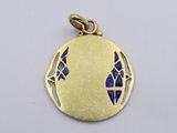 a close up of a gold pendant with a blue bird on it