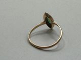 an image of a gold ring with a green stone