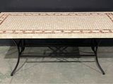 une table avec un plateau en mosaïque et des pieds en fer