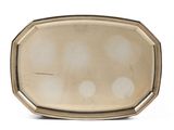 une assiette ancienne en argent, ornée de quatre points sur fond blanc