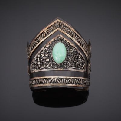 un bracelet en argent orné d'une pierre verte au centre