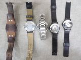 four different types of watches sitting on a table
