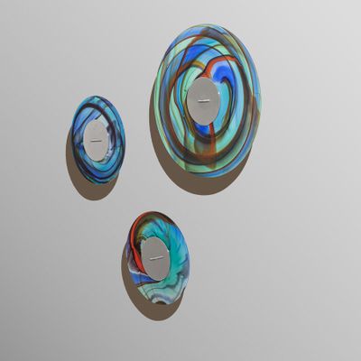 trois œuvres d'art posées sur une surface blanche