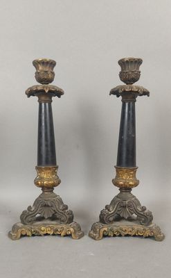 une paire de bougeoirs noirs et dorés posés sur une table