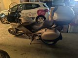 a silver motorcycle parked in a garage next to a white car