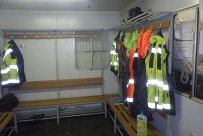 de nombreux gilets de sécurité accrochés à un mur dans une pièce