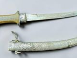 pair of antique silverware knifes on a white surface