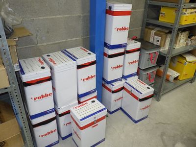 plusieurs cartons sont empilés les uns sur les autres dans un entrepôt