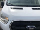 a white ford transit truck parked in a parking lot