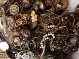 a pile of assorted jewelry on a white surface