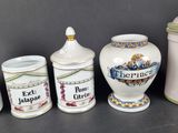 several different types of ceramic containers are lined up on a table