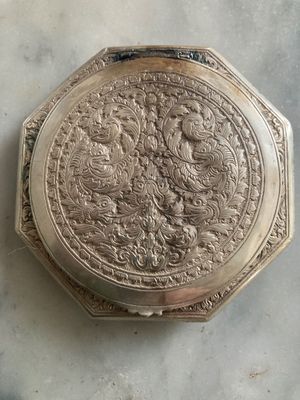 une vieille boîte en argent posée sur un comptoir en marbre