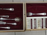 a box with silverware in it on a tile floor