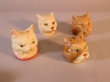 quatre chats en céramique posés les uns à côté des autres sur une table blanche