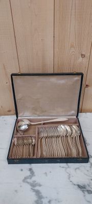 a box with silverware in it on a marble surface