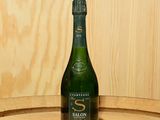 une bouteille de vin posée sur un tonneau en bois