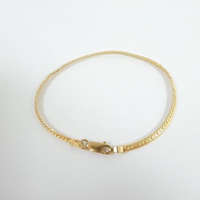 a gold bracelet with a snake clasp on a white background