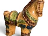 a ceramic horse that is sitting on a white surface