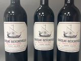 trois bouteilles de vin rouge posées sur une table