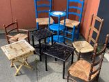 Plusieurs chaises et une table sont disposées en cercle sur le trottoir.