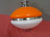 an orange and white object sitting on a pink surface