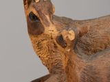 a wooden sculpture of a dog and a cat on a piece of wood