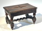 une petite table en bois sur laquelle est posée une croix