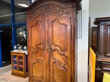 une grande armoire en bois dans une pièce où se trouve une chaise jaune