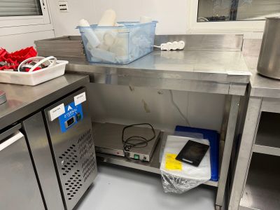 une cuisine avec des plans de travail en inox et un téléphone posé sur le plan de travail