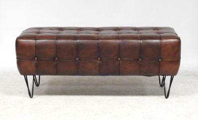 a brown leather bench with metal legs and a buttoned top