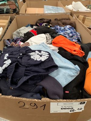 a cardboard box filled with clothes and other items