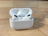 une boîte transparente contenant une paire d'AirPods, posée sur une table