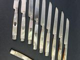 several knives are lined up on a table with a knife in front of them