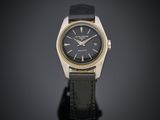 une montre-bracelet plaquée or, avec cadran noir et bracelet en cuir noir