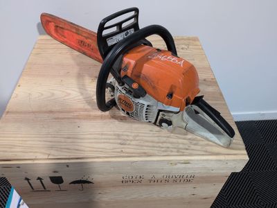 an orange chainsaw sitting on top of a wooden box